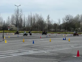 Cursanți pe motociclete printre conuri, exercițiu practic